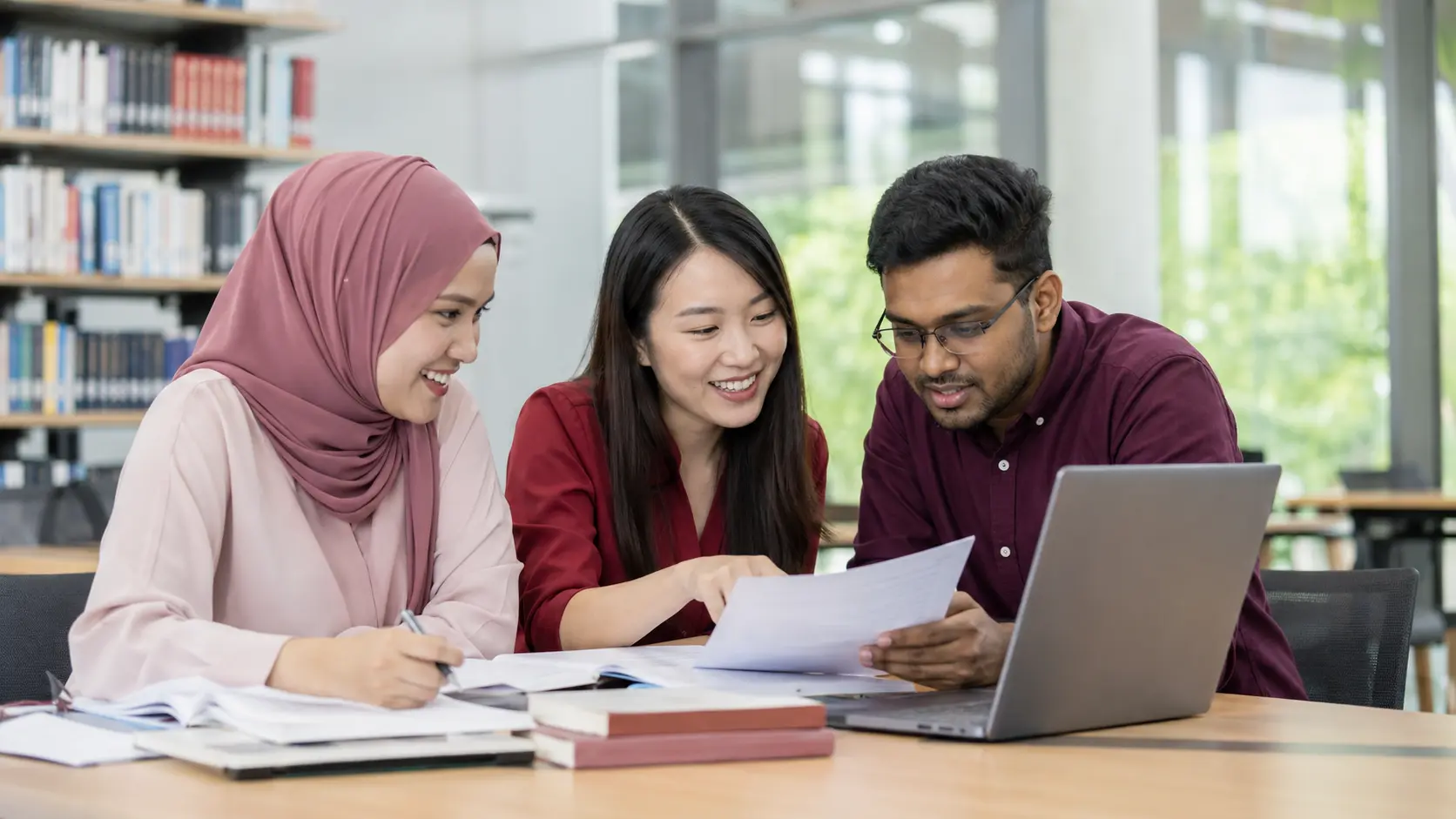 A diverse group of Malaysian postgraduate researchers preparing a manuscript for journal submission